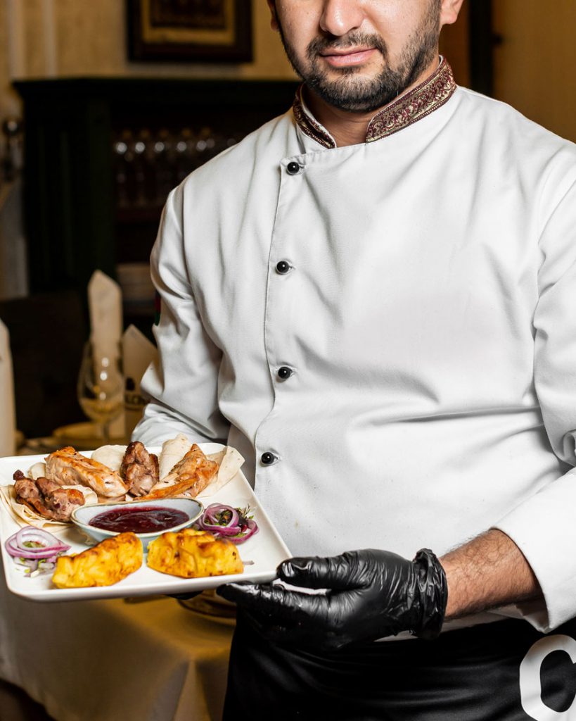 Chef holding dinner plate of food