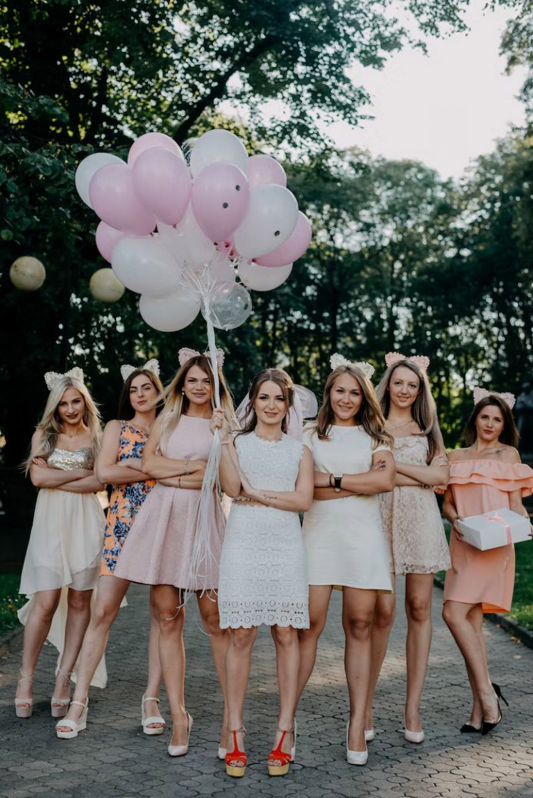 Group of girlfriends at a bachelorette gathering outside with balloons