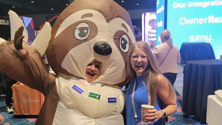 Breathe Easy Rentals' owner, Brittany Blackman, posing with a sloth mascot at the VRMA conference